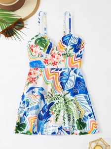 Detail of tropical floral print featuring palm leaves and blue birds on a tankini swimsuit