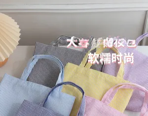 Detail view of colorful striped quilted tote bags in various soft candy tones
