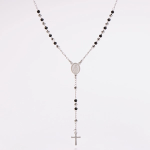 Dettaglio macro della collana rosario argento con grani neri e pendente a croce