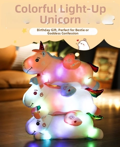 Stacked glowing unicorn plush pillows emitting colorful soft lights in a dark room
