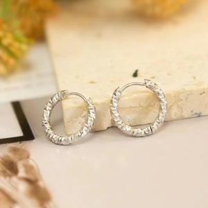 Textured silver hoop earrings with hammered finish in premium minimalist style