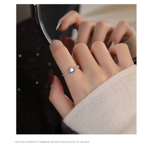 Detail of s925 sterling silver ring featuring a round moonstone on a female finger