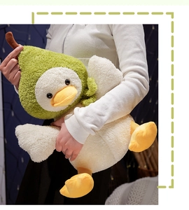 Détail d'une peluche canard en sweat à capuche poire verte tenue dans un intérieur