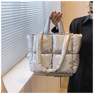 Detail of silver metallic quilted tote bag with soft padded stitching and dual straps