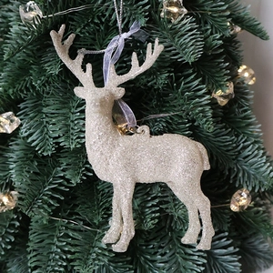 Sparkling champagne glitter reindeer Christmas ornament hanging on a pine tree branch
