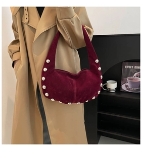 Close-up of wine red suede hobo bag with large silver rivets and half-moon design