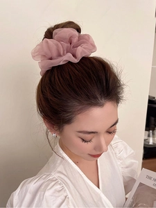 Close-up of oversized pink organza scrunchie showing pleated texture and soft fabric detail