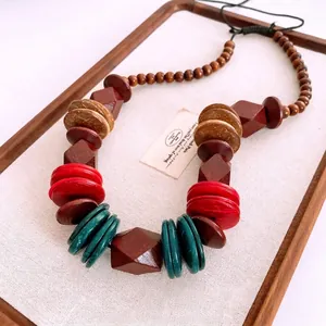 Bohemian beaded necklace with wood and coconut shell discs on a rustic display tray