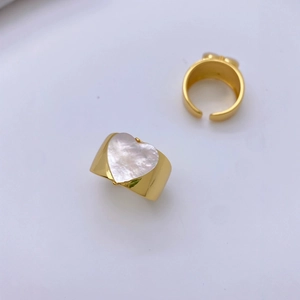 Gold plated adjustable open rings set with heart shell inlay on white background