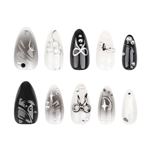 Faux ongles 3D avec design marbré noir, nœuds 3D et accents d'étoiles argentées en amande