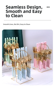 Close-up of marble pattern ceramic handles and golden stainless steel cutlery with a rack
