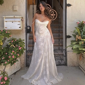 Close-up of white floral embroidery and 3D butterfly appliques on a tulle maxi dress