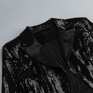 Détail du revers et des coutures d'épaule d'un blazer noir à paillettes brillantes