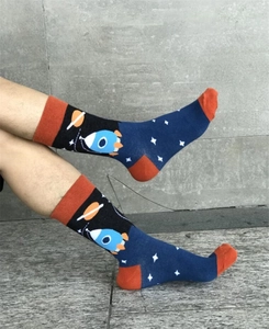 Detail view of cotton crew socks featuring blue rockets and planets on a starry background