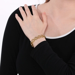 Gros plan détaillé d'un bracelet en acier inoxydable plaqué or sur un poignet féminin