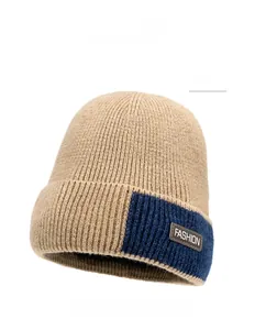 Detail of khaki ribbed knit beanie with fashion leather patch and navy contrast brim