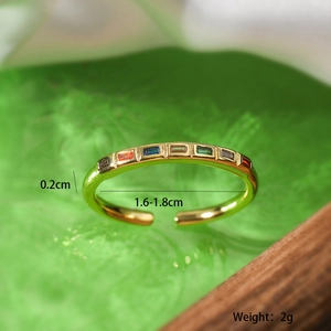 Macro shot of gold geometric open ring with rainbow zircon and product size specifications