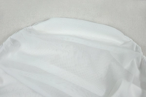 Close-up of white translucent mesh fabric showing delicate net texture and sheer material