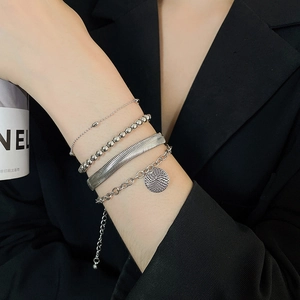 Dettaglio del set di quattro bracciali in argento con ciondolo tondo strutturato