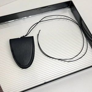 Détail du support de lunettes en cuir noir grainé avec cordon et coutures précises
