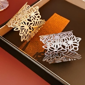 Close-up of vintage hollow flower metal bangles in polished gold and silver finishes