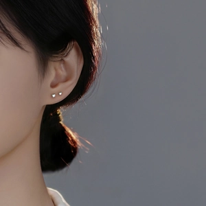 S999 sterling silver heart stud earrings with iridescent cubic zirconia on female ear