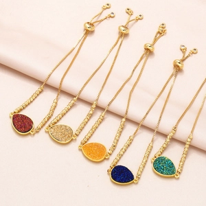 Detailed view of five adjustable gold box chains with multicolored teardrop crystals
