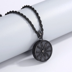 Vue détaillée du pendentif soleil noir avec motifs de flammes sur chaîne torsadée