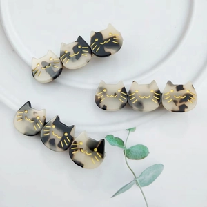 Detailed macro view of three-headed acetate cat hair clips in tortoiseshell patterns