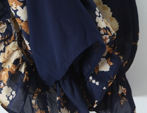 Detail shot of navy floral dress showing ruffled hem layers and high-quality lining seam