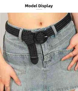 Close-up of black woven belt with a large round buckle on a denim dress