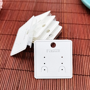 Macro detail of white jewelry display cards with Fashion print and hanging holes