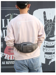 Gray waterproof waist bag for men featuring multiple zippers and adjustable strap shown on model