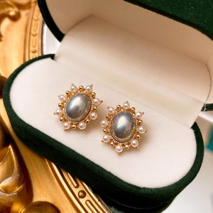 Macro detail of French vintage oval stud earrings with grey stones and pearls in a velvet box