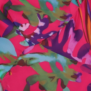 Close-up of tropical floral print on pink fabric with refined stitching details