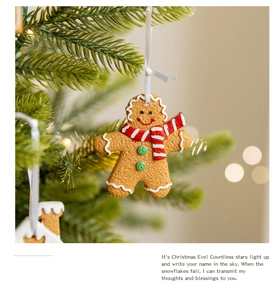 Macro detail of gingerbread man ornament with red scarf on a festive Christmas tree branch