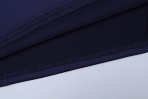 Détail de la texture du tissu bleu marine et de la double couture précise sur la robe
