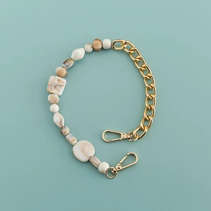 Detail of bohemian acrylic link chain with gold metal and marble resin beads