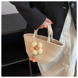 Detail of hand-woven beige cotton rope handbag featuring a 3D yellow floral ornament