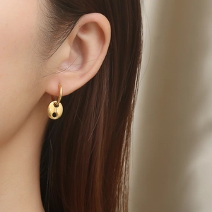 Close-up of elegant gold pig nose link hoop earrings worn for a modern aesthetic look
