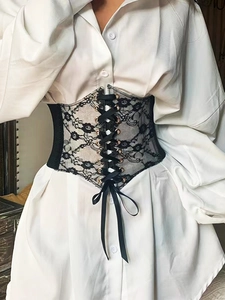 Detail of floral lace corset belt with bronze eyelets and black ribbon lacing on a model