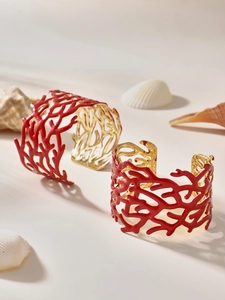 Détails des bracelets corail ajourés rouges avec doublure dorée et décor marin