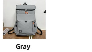 Close-up of gray waterproof travel backpack with orange zipper pulls and side buckles