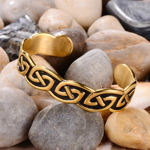 Detail of vintage Viking Celtic knot open bracelet on natural stone background