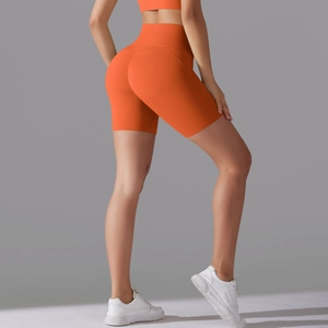 Detailed macro view of the seamless high waist and bright orange fabric of yoga shorts