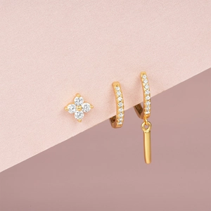 Detailed view of three gold S925 earrings with flower stud and sparkling zircon hoops