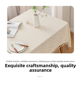 Detailed close-up of white daisy floral print and fringe edges on cotton linen tablecloth
