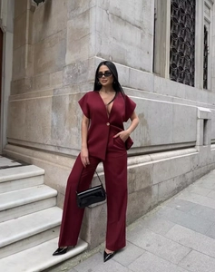 Macro detail of wine red V-neck blazer and wide-leg trousers set with button detail