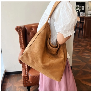 Close-up of brown suede tote bag showing large capacity and soft texture on shoulder