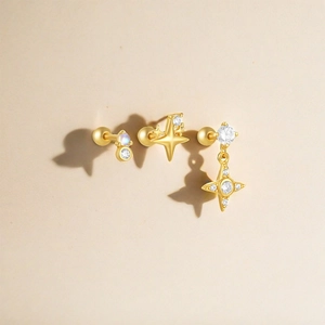 Close-up of gold S925 silver moon and star studs with cubic zirconia and screw backs